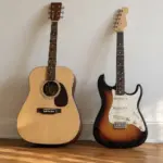 Acoustic and electric guitar leaning side by side against a wall